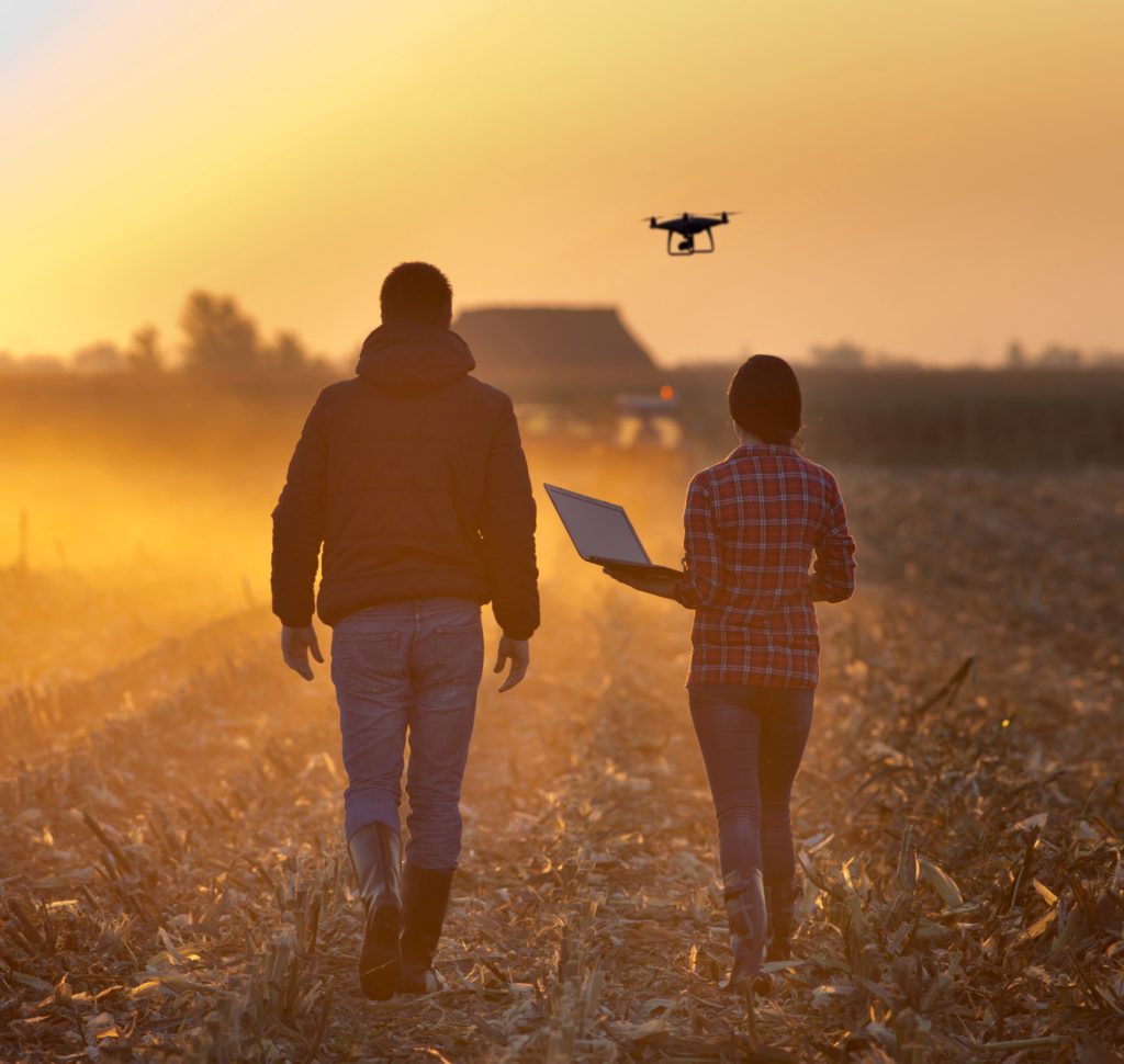 Farmers with drone on field